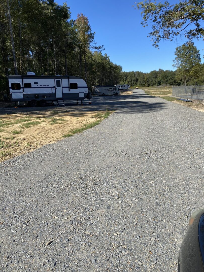 A road with gravel and trees in the background.